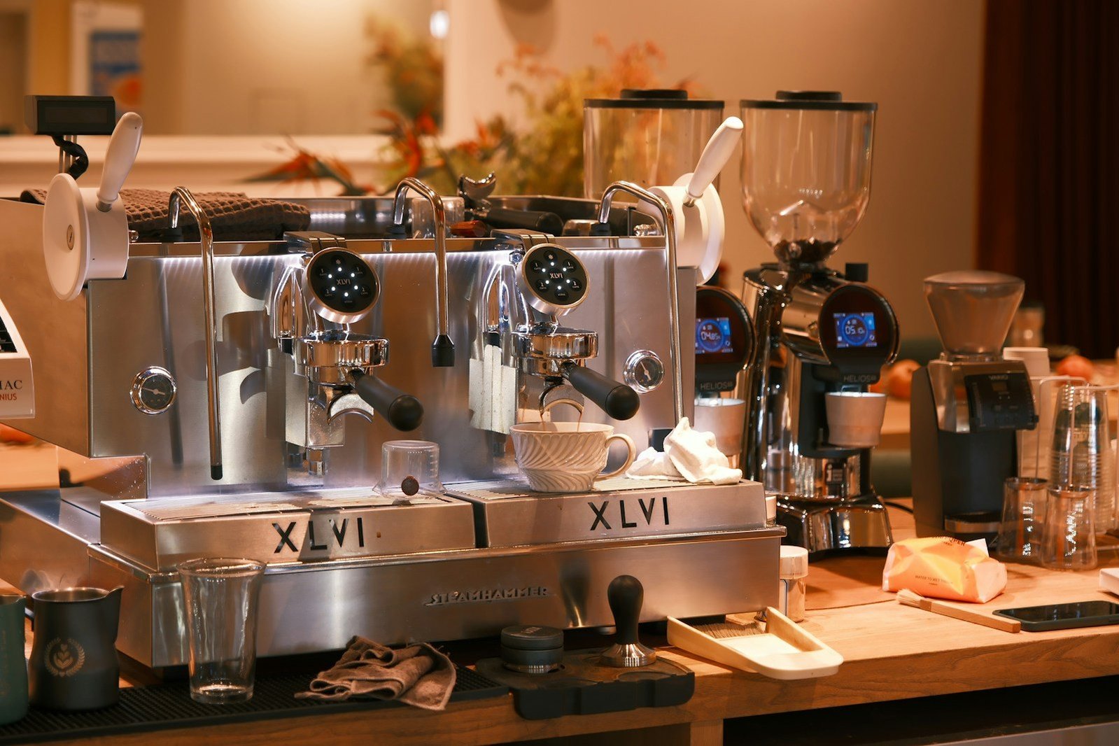 Una máquina de espresso y accesorios de café en una barra de madera.