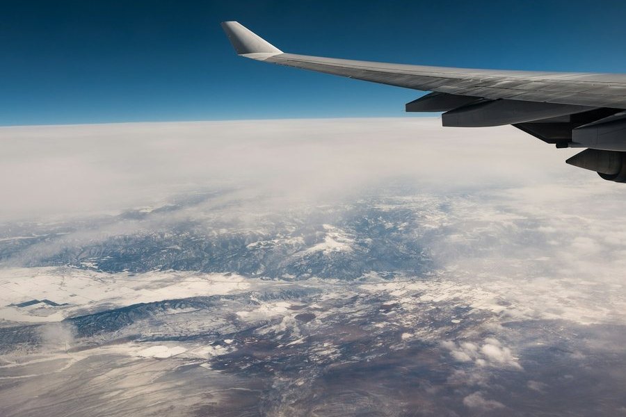 Ala de un avión y montañas nevadas vistas desde el aire.