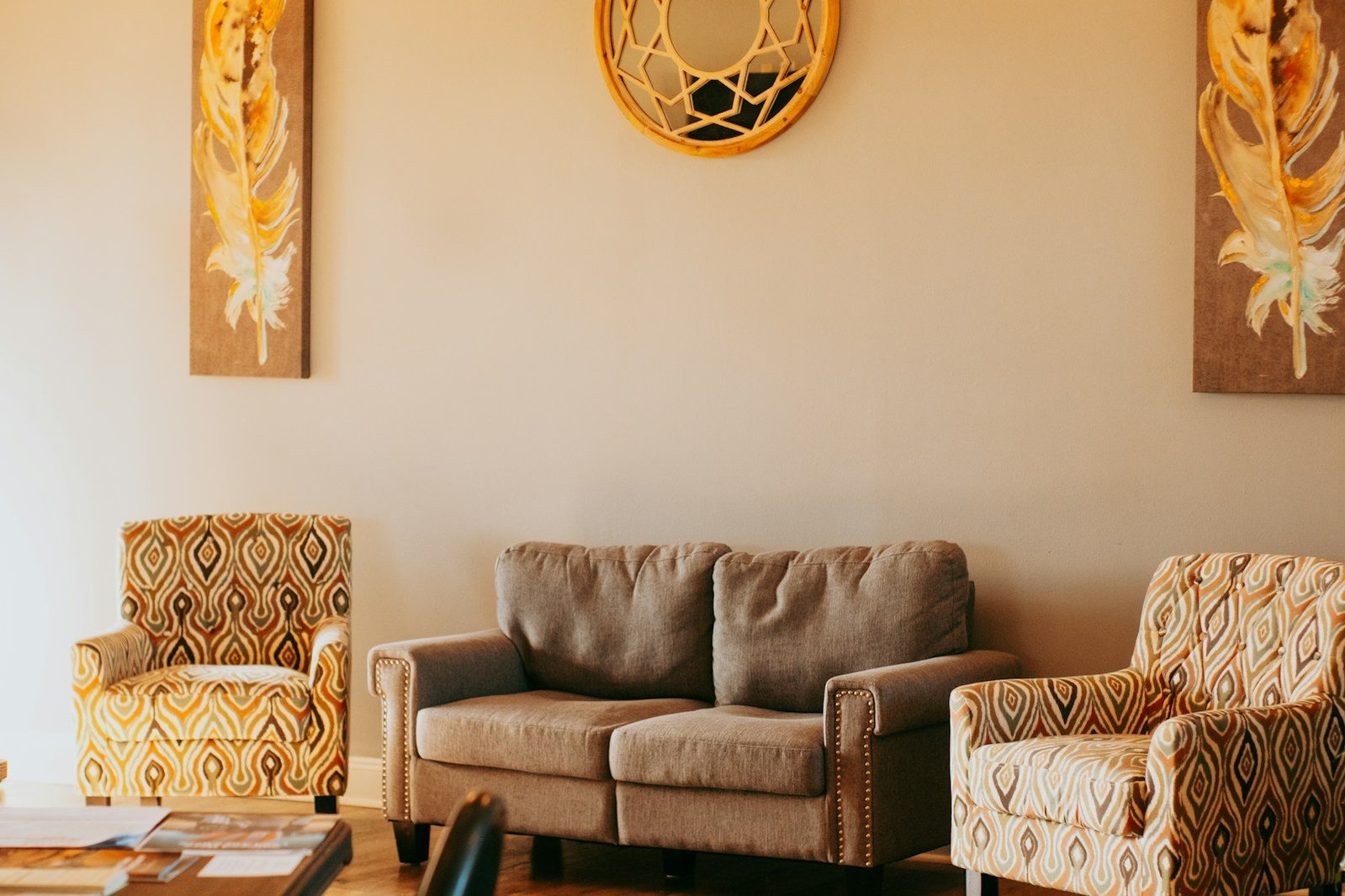 Sofá y dos sillones con estampados cálidos en un salón.