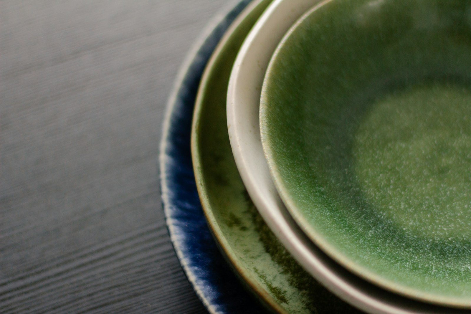 Platos de cerámica esmaltada en verde, blanco y azul.