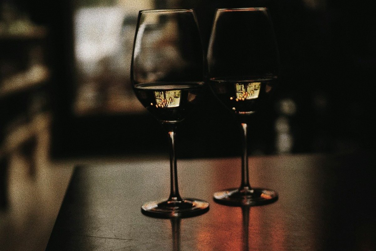 Dos copas con vino sobre una mesa de madera.